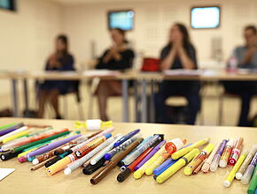 Vue sur des crayons colorés posés sur une table lors d'une réunion - Agrandir l'image, fenêtre modale